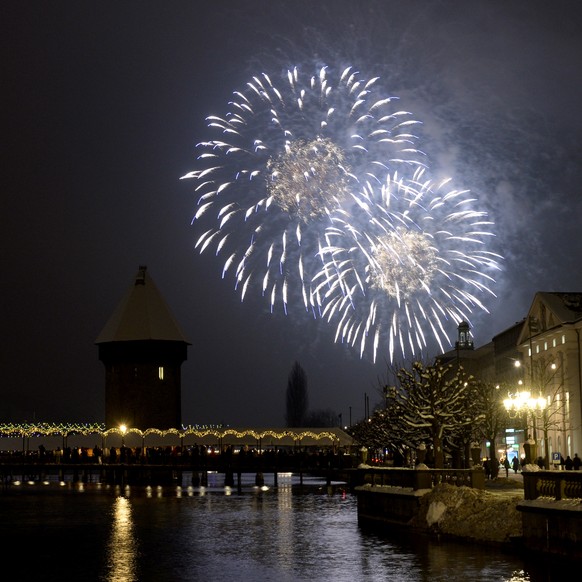 Mit einem Feuerwerk neben der Kappelerbruecke wird in der Stadt Luzern das neue Jahr begruesst am Freitag, 1. Januar 2015. (KEYSTONE/Urs Flueeler)

New year fireworks explode over the famous Chapel  ...