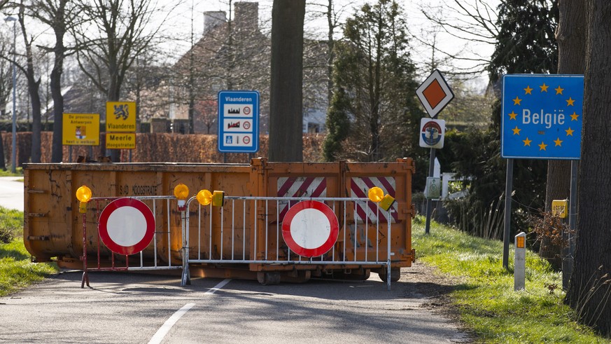 A container and barriers block a backroad used by locals on the Netherlands border with Belgium between Chaam, southern Netherlands, and Meerle, northern Belgium, Monday, March 23, 2020. Both countrie ...