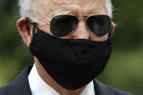 Democratic presidential candidate, former Vice President Joe Biden wears a face mask to protect against the spread of the new coronavirus as he and Jill Biden depart after placing a wreath at the Dela ...