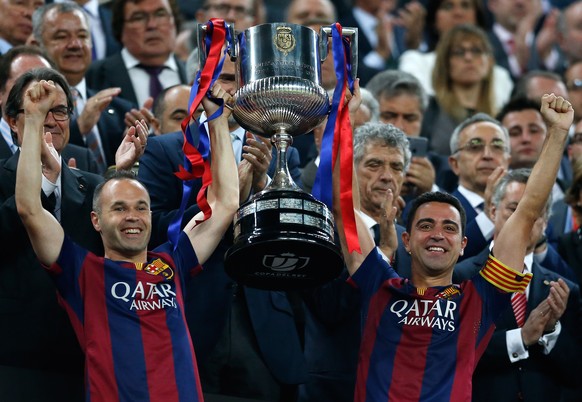 Barcelona&#039;s Andres Iniesta, left, and Xavi Hernandez lift the trophy after winning the final of the Copa del Rey soccer match between FC Barcelona and Athletic Bilbao at the Camp Nou stadium in B ...