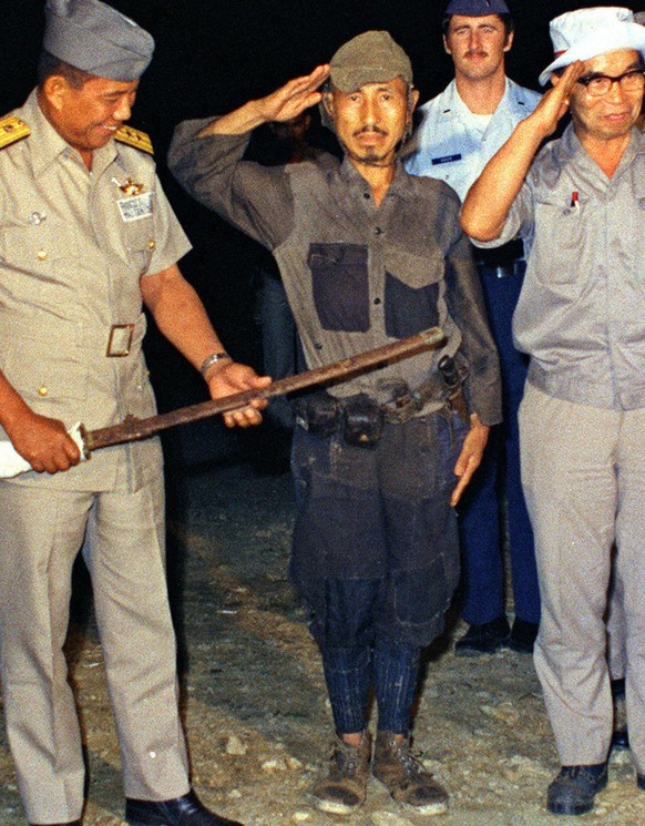FILE - In this March, 1974 photo, Hiroo Onoda, center, salutes after handing over his military sword on Lubang Island, Philippines, when he comes out of hiding in the jungle. Onoda, the last Japanese  ...