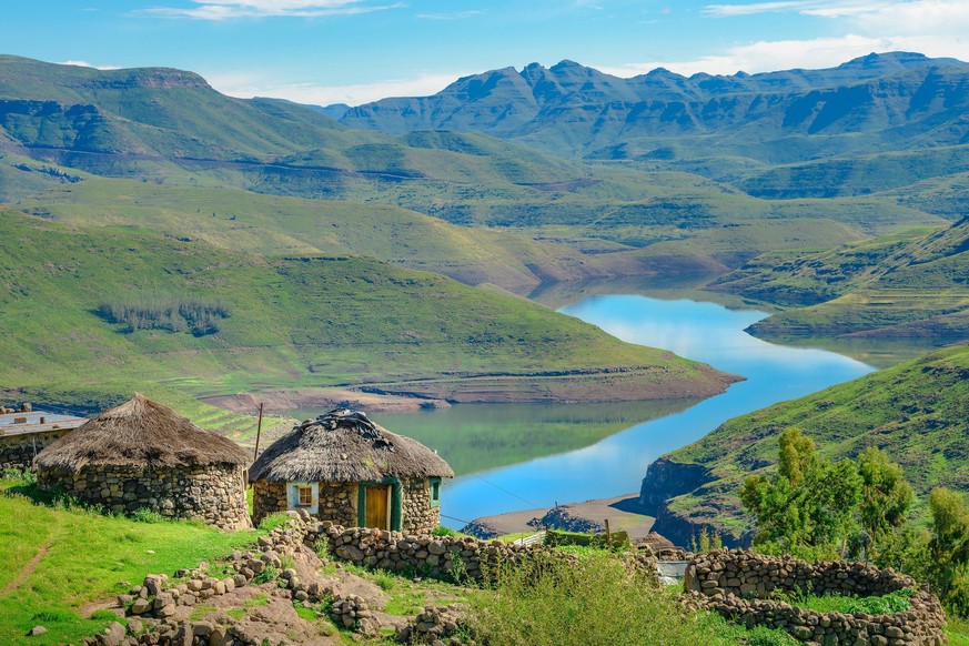 Traditionelle Hütten umgeben von wunderschöner Natur im afrikanischen Binnenstaat Lesotho.