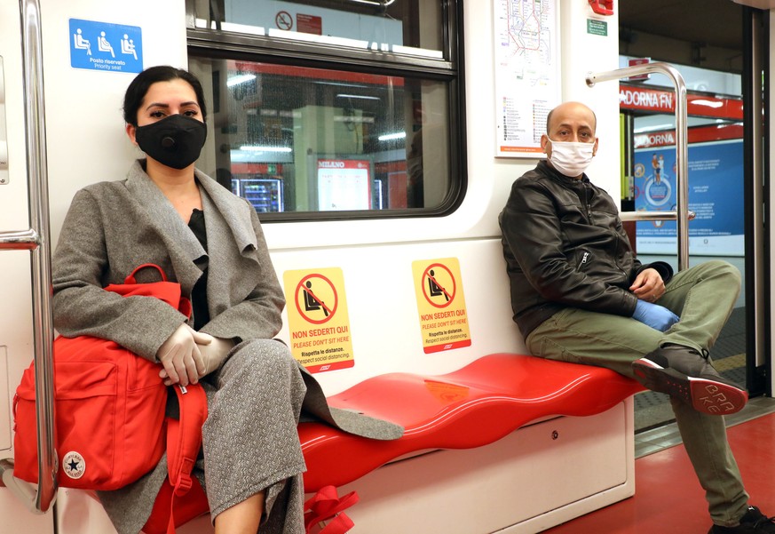 epa08386984 People wearing face masks respect social distancing measures while seated inside a subway carriage in Milan, northern Italy, 27 April 2020, during the coronavirus disease (COVID-19) pandem ...