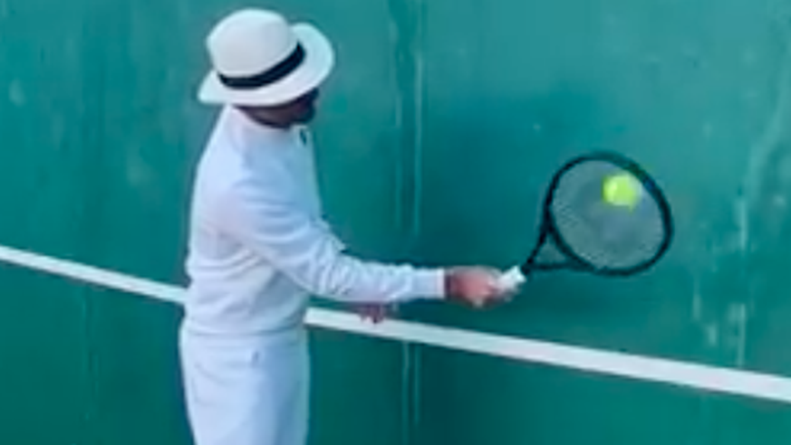 Ganz in Weiss mit Hut: Roger Federer übt an der Wand.