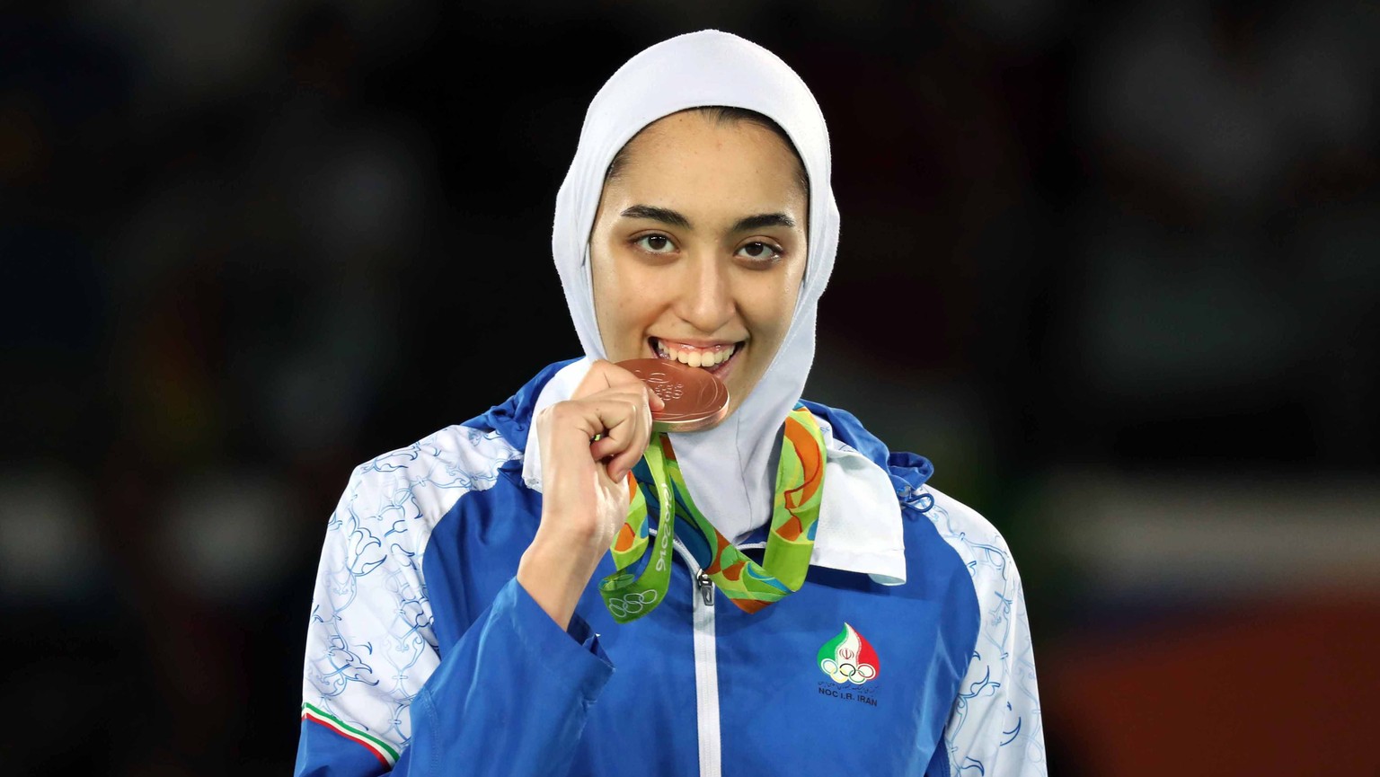 epa08122435 (FILE) - Joint bronze medalist Kimia Alizadeh Zenoorin of Iran bites her medal as she poses on the podium for the women&#039;s -57kg competition of the Rio 2016 Olympic Games Taekwondo eve ...