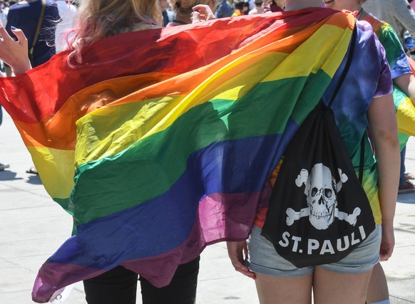 In Regenbogenfahnen geh�llt nehmen zwei junge Frauen an der Christopher Street Parade in Freiburg teil.Foto:Winfried Rothermel *** Wrapped in rainbow flags, two young women take part in the Christophe ...