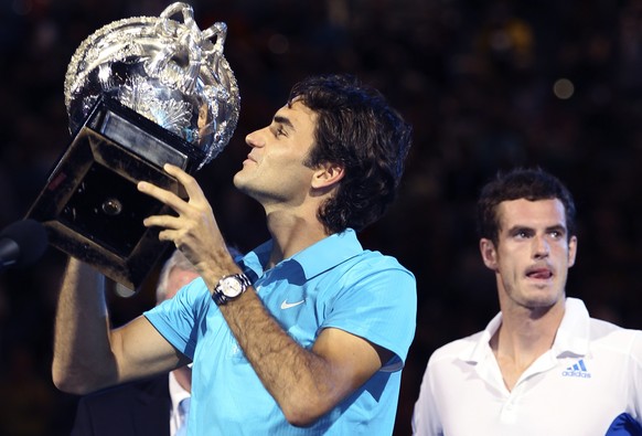 Roger Federer of Switzerland, left, holds up the trophy during the awarding ceremony, after beating Andy Murray of Britain, right, to win the Men&#039;s singles final match at the Australian Open tenn ...