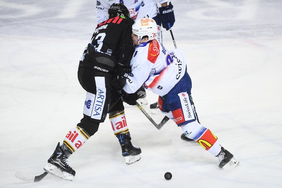 Lugano&#039;s player Giovanni Morini, left, fight for the puck with Zurich&#039;s player Tim Berni, right, during the preliminary round game of National League Swiss Championship 2018/19 between HC Lu ...