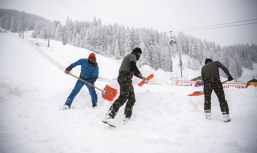 epa09075791 Soldiers clear the finishing area of snow, prior to the FIS Alpine Ski World Cup finals, in Parpan - Lenzerheide, Switzerland, 15 March 2021. The first downhill training was cancelled due  ...