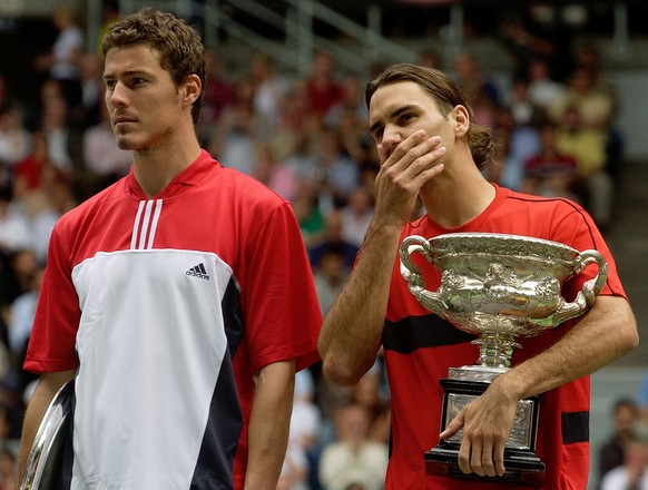 Roger Federer of Switzerland, right, holds the trophy after winning the men&#039;s final against Marat Safin, left, of Russia at the Australian Open in Melbourne, Australia, Sunday, Feb. 1, 2004. Fede ...