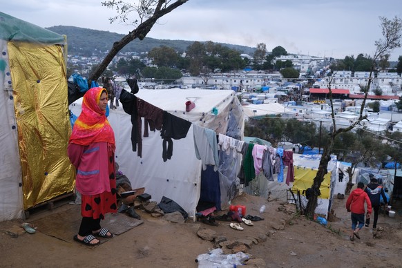 A migrant stands next to their makeshift tent outside the perimeter of the overcrowded Moria refugee camp on the northeastern Aegean island of Lesbos, Greece, Wednesday, March 11, 2020. Camps on Lesbo ...