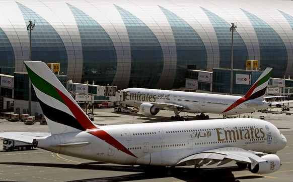 FILE- In this May 8, 2014 file photo, Emirates passenger planes are in use at Dubai airport in United Arab Emirates. Dubai Airports said Monday it plans to add 10 more A380 gates with air bridges at D ...