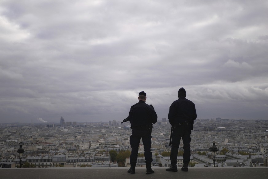 FILE - In this Oct. 30, 2020, file photo, police officers stand guard next to the Sacre Coeur basilica in Paris, following an attack at a church in the Mediterranean city of Nice. Scrubbing France cle ...