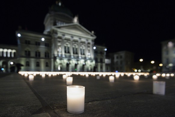 epa09028822 Activists lit almost 9,200 candles to commemorate the people who died of Covid-19 in Switzerland, on the Bundesplatz, in front of the Federal Palace in Bern, Switzerland, 21 February 2021. ...