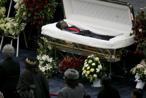 Mourners walk by the casket of James Brown during the viewing at the public funeral ceremony for the singer at the James Brown arena in Augusta, Ga., Saturday, Dec. 30, 2006. (AP Photo/John Bazemore)