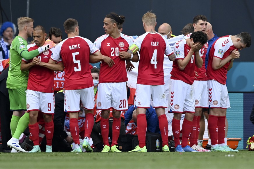 Denmark players make a wall around teammate Christian Eriksen being assisted by medics during the Euro 2020 soccer championship group B match between Denmark and Finland at Parken Stadium in Copenhage ...