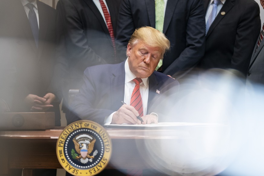 epa07908680 US President Donald J. Trump signs two executive orders on transparency in federal guidance and enforcement, in the Roosevelt Room of the White House in Washington, DC, USA, 09 October 201 ...