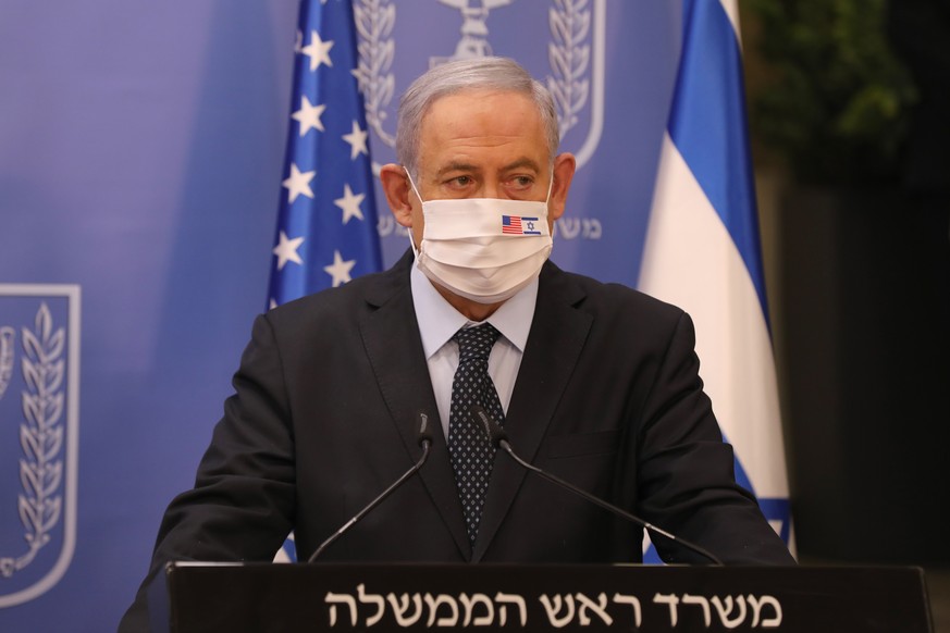 epa08517179 Israeli Prime Minister Benjamin Netanyahu wearing a face mask during a media statement with US special representative for Iran Brian Hook at the Prime Minister&#039;s Office in Jerusalem,  ...
