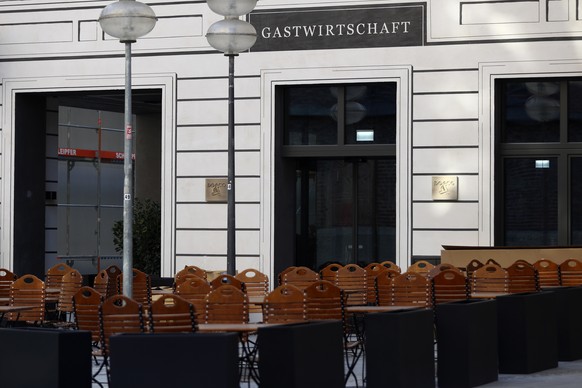 Empty chairs and tables stand outside at a restaurant downtown in Munich, Germany, Easter Sunday, April 4, 2021. (AP Photo/Matthias Schrader)