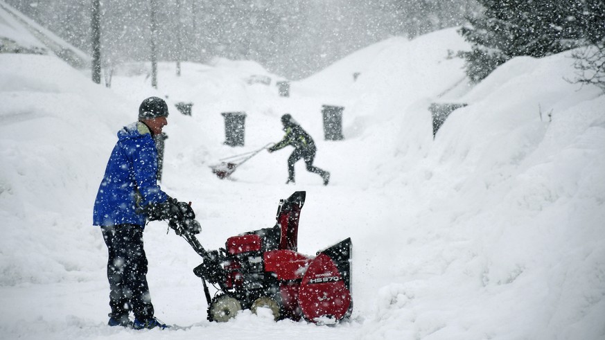 People clear snow from a street in a residential area after heavy snowfall in Tromso, Northern Norway, Tuesday, March 31, 2020. (Rune Stoltz Bertinussen/NTB scanpix via AP)