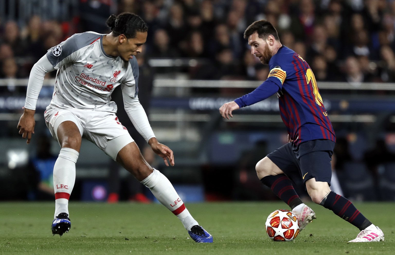 Liverpool&#039;s Virgil Van Dijk, left, vies for the ball with Barcelona&#039;s Lionel Messi during the Champions League semifinal, first leg, soccer match between FC Barcelona and Liverpool at the Ca ...