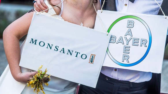 epa06771466 (FILE) - A woman and a man dressed as bride and groom pose during an action &#039;marriage made in hell&#039; to denounce the threat posed by the planned merger of Bayer and Monsanto in fr ...
