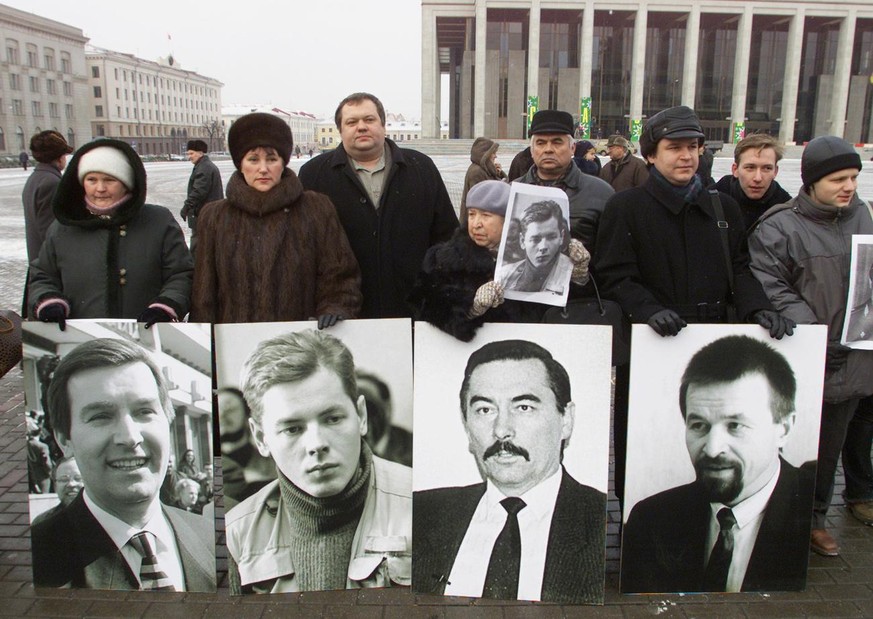 Protesters hold portraits of the missing people in a central square of the Belarusian capital Minsk, Tuesday, December 10, 2002. About 200 protesters gathered to criticize the stalled investigations i ...