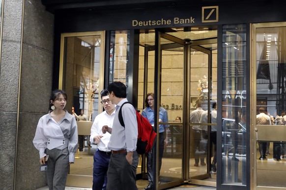 People leave Deutsche Bank in New York, Monday, July 8, 2019. Germany&#039;s struggling Deutsche Bank said Sunday it would cut 18,000 jobs by 2022, downsizing its volatile investment banking division  ...
