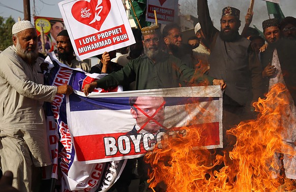 epa08777764 People burn an effigy of French President Macron over his comments on Prophet Muhammad caricatures, in Karachi Pakistan, 27 October 2020. A group of protestors gathered to protest Macron&# ...