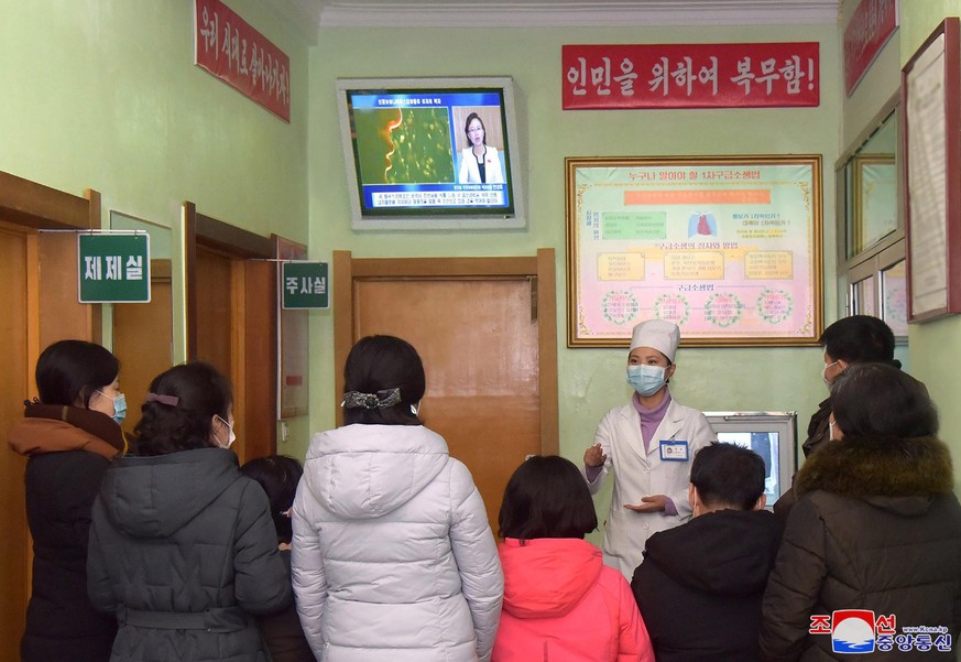 epa08218860 A photo released by the official North Korean Central News Agency (KCNA) shows a health worker speaking to people about the Covid-19 and coronavirus, in Pyongyang, Democratic People&#039;s ...