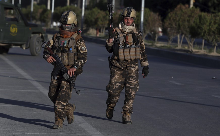 Afghan security forces inspect the site where a bus carrying local TV station employees hit a roadside bomb in Kabul, Afghanistan, Saturday, May 30, 2020. (AP Photo/Rahmat Gul)