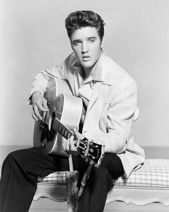 1956: Rock and roll singer Elvis Presley strums his acoustic guitar in a portrait in 1956. (Photo by Michael Ochs Archives/Getty Images)