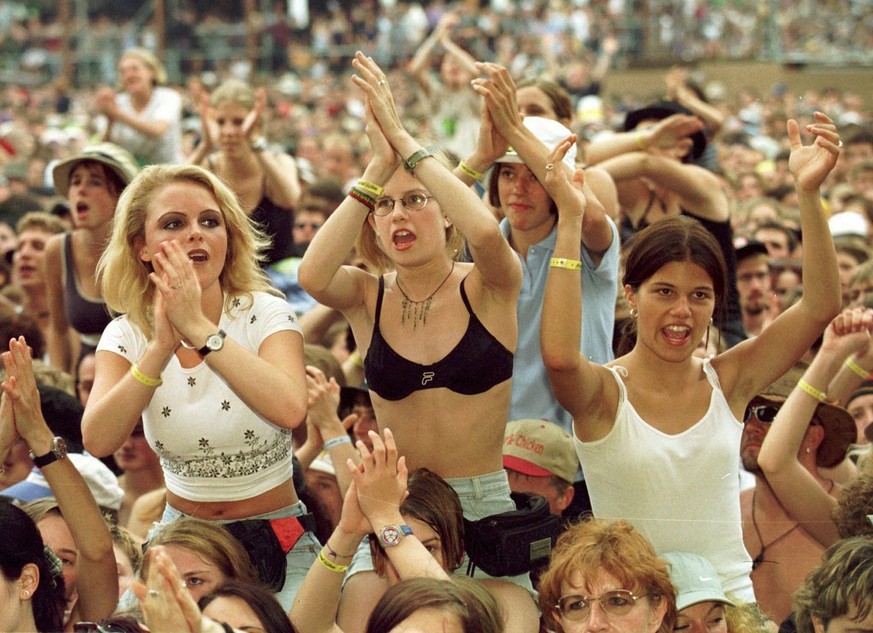 Fans am Open Air St. Gallen feiern den Auftritt des Schweizer Rockstars Goelae, aufgenommen am Samstag, 26. Juni 1999, im Sittertobel. (KEYSTONE/Arno Balzarini)