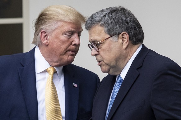 epa08939623 (FILE) US President Donald J. Trump (L) hands over the podium to US Attorney General William Barr (R) while participating in an announcement on US citizenship and the census, in the Rose G ...