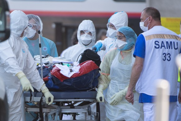 epa08355669 Emergency medical staff disembark a patient from a TGV high speed train from Paris next to an ambulance, at the train station in Bordeaux, France, 10 April 2020. More than 40 patients with ...