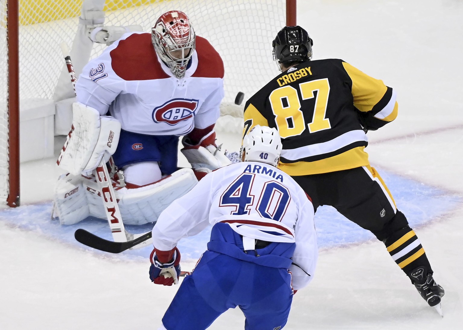 Pittsburgh Penguins center Sidney Crosby (87) scores on Montreal Canadiens goaltender Carey Price (31) as teammate Joel Armia (40) looks on during the first period of an NHL hockey playoff game Saturd ...