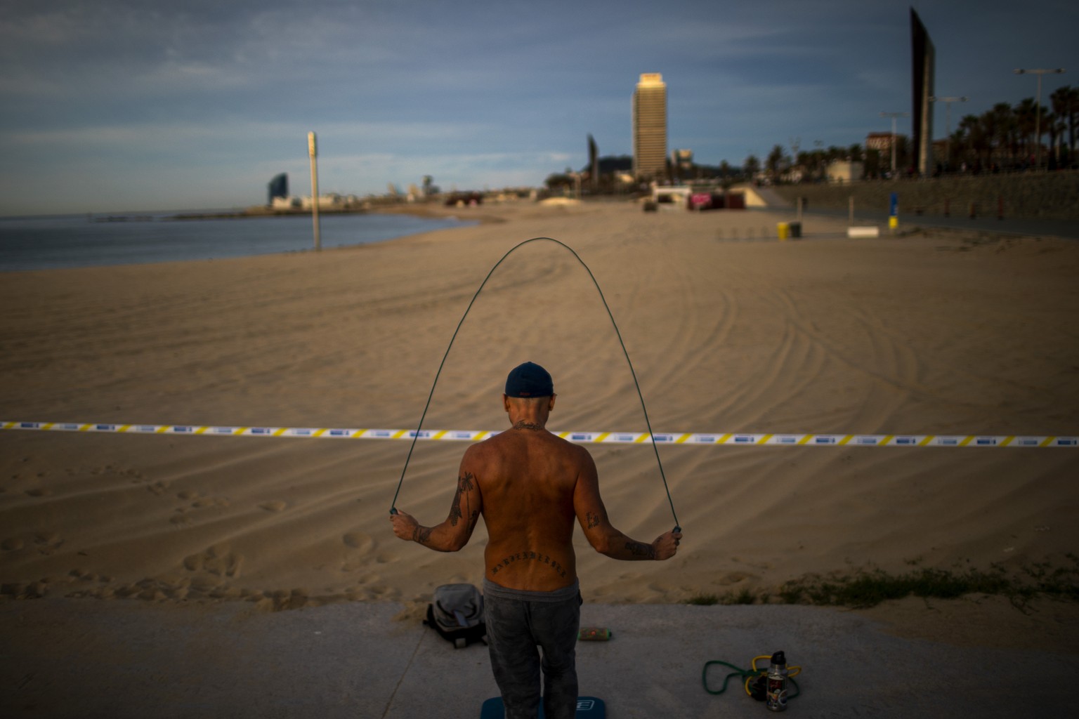 A man exercises next to a closed beach in Barcelona, Spain, Saturday, May 2, 2020. Spaniards have filled the streets of the country to do exercise for the first time after seven weeks of confinement i ...