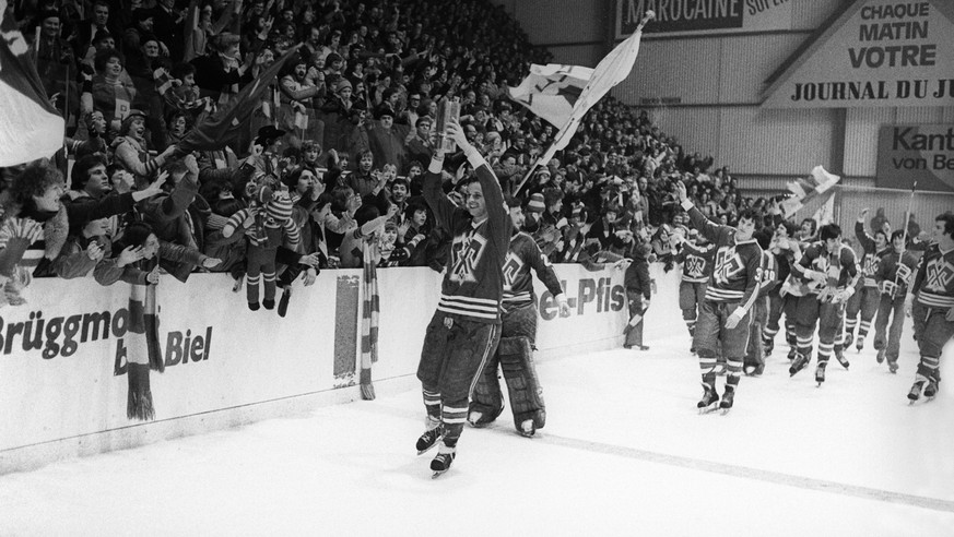 Aldo Zenhaeusern, mit Pokal, und weitere Spieler des EHC Biel feiern am 26. Februar 1978 mit den Zuschauern den erstmaligen Gewinn der Schweizer Eishockeymeisterschaft. (KEYSTONE/Str)