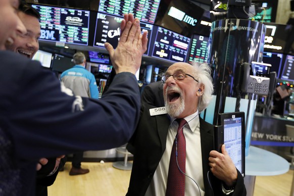 Traders Peter Tuchman, right, slaps a high five before the closing bell on the floor of the New York Stock Exchange, Wednesday, Dec. 26, 2018. The Dow closed up more than 1,000 points in best day for  ...