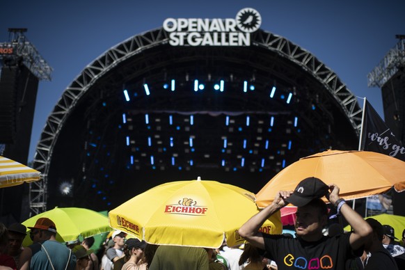 Visitors shelter from the sun in front of the main stage on the second day of the 43. St. Gallen Openair, on Friday, June 28, 2019, in St. Gallen, Switzerland. The music festival takes place from June ...