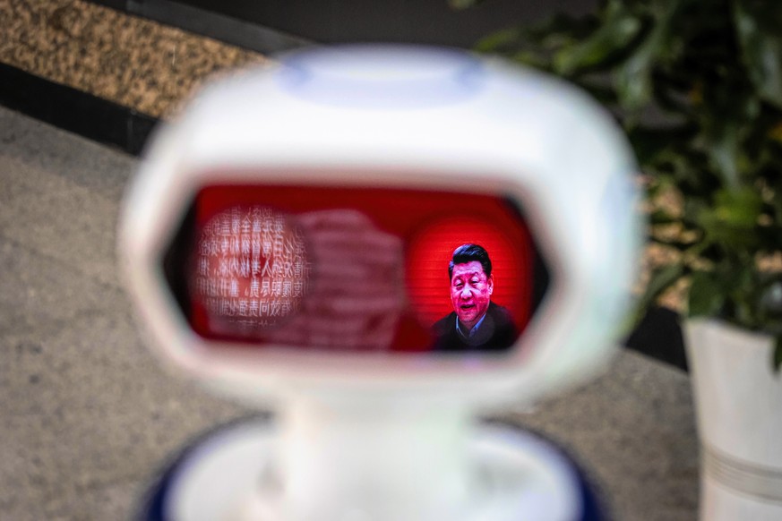 epaselect epa08279793 A picture of Chinese president Xi Jinping is reflected in the visor of robot used to check visitors&#039; body temperature for possible coronavirus infections, at the entrance of ...