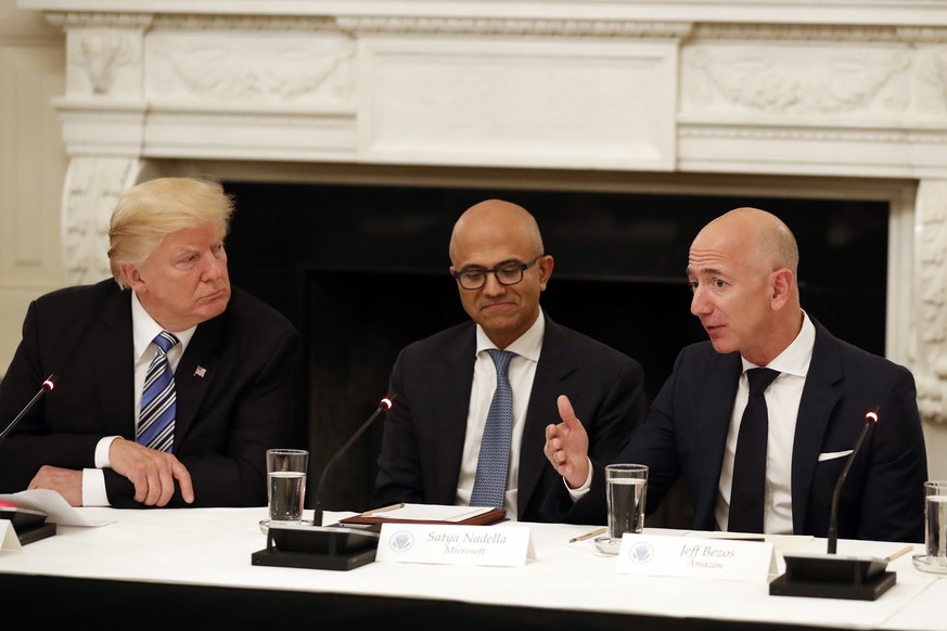 President Donald Trump, left, and Satya Nadella, Chief Executive Officer of Microsoft, center, listen as Jeff Bezos, Chief Executive Officer of Amazon, speaks during an American Technology Council rou ...