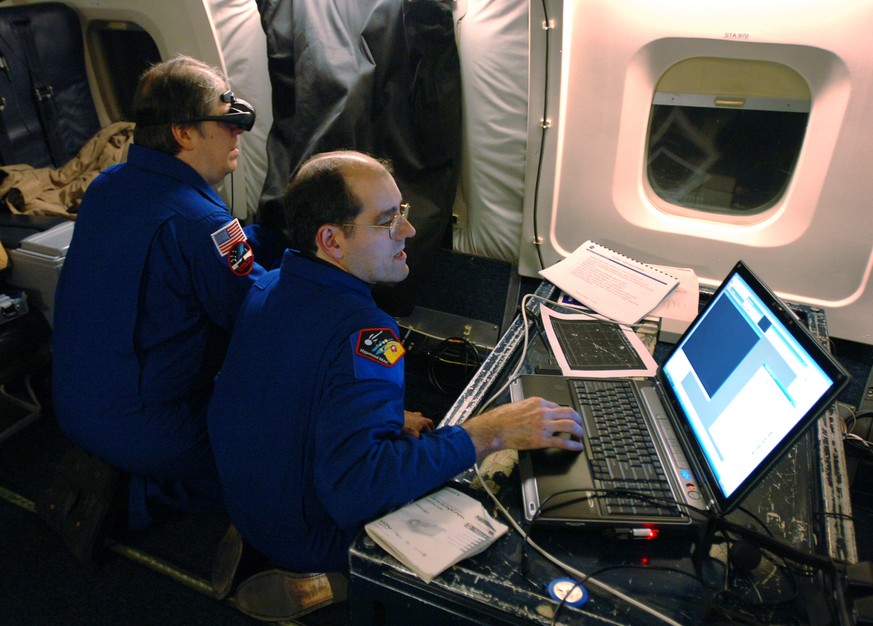 Research Scientist with the SETI Institute and Principal Investigator for the Stardust Sample Return Capsule Re-entry Observing Campaign Peter Jenniskens, right, works on his computer as Michael Koop  ...