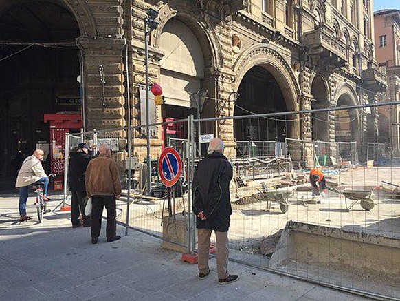 Alte Männer begutachten eine Baustelle in Italien.