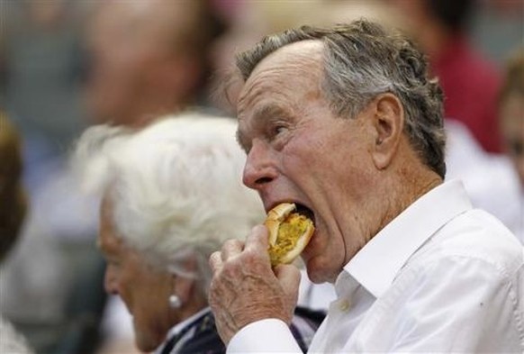 George H. W. Bush verdrückt einen Chilli-Cheese-Hot-Dog.