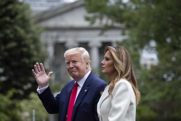 President Donald Trump, accompanied by first lady Melania Trump, waves while walking as they return on Marine One on the South Lawn of the White House, Monday, May 25, 2020, in Washington. Trump is re ...