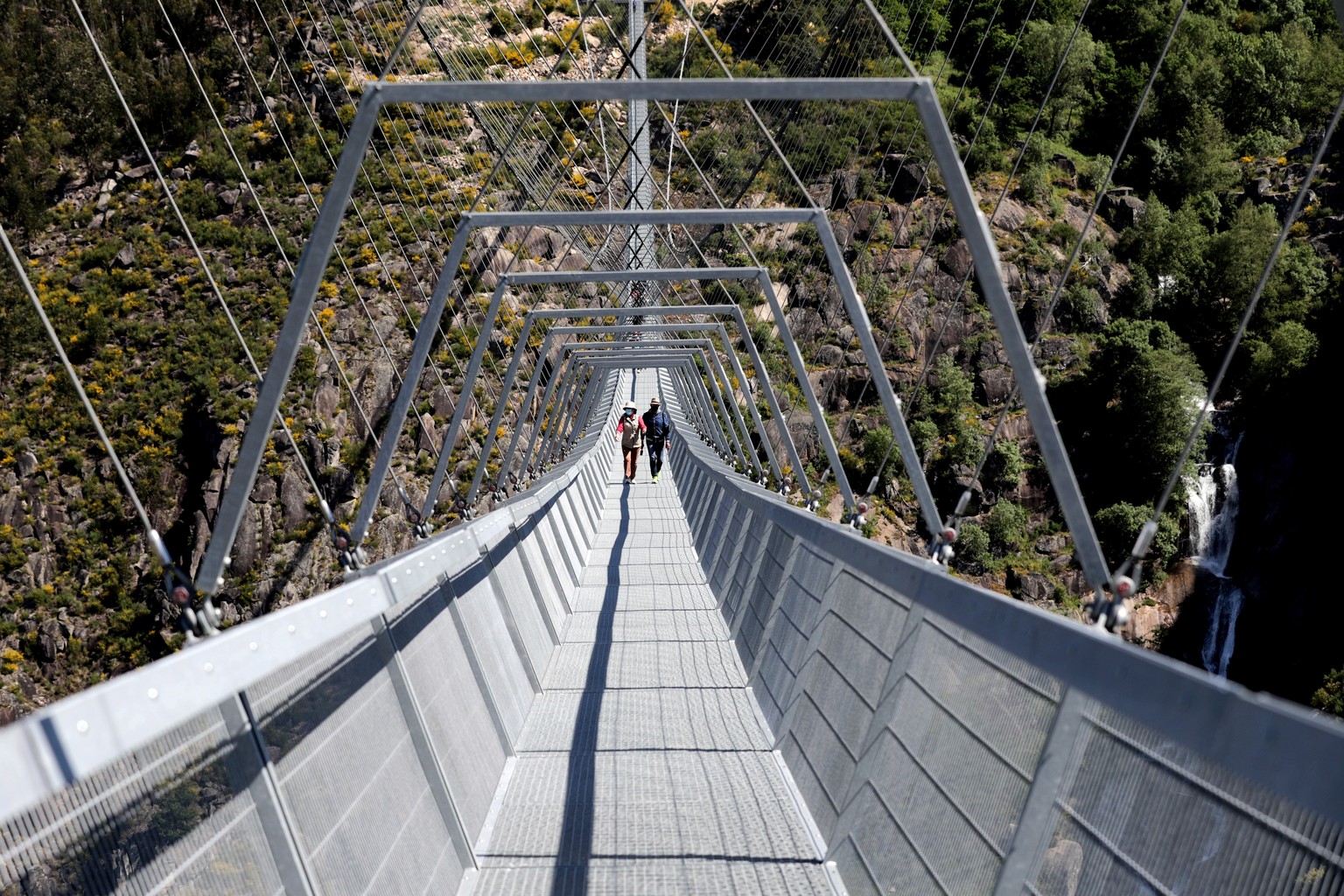 epa09164741 Two people walk on &#039;516 Arouca&#039;, considered the largest pedestrian suspension bridge in the world, at 516 meters long and 175 meters high, in Arouca, Portugal, 16 April 2021 (iss ...