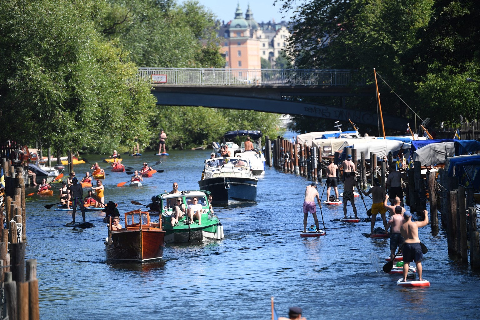 epa08591562 People enjoy boat rides, canoe paddling and stand up paddlle in the nearly 30 degrees Celsius summer weather at the Palsund canal in Stockholm, Sweden, 08 August 2020. EPA/Fredrik Sandberg ...