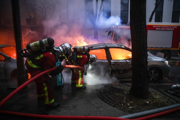 epaselect epa08865030 Firefighters extinguish a fire as several cars burn during a protest against France&#039;s controversial global security law, during a protest in a street between Porte des Lilas ...