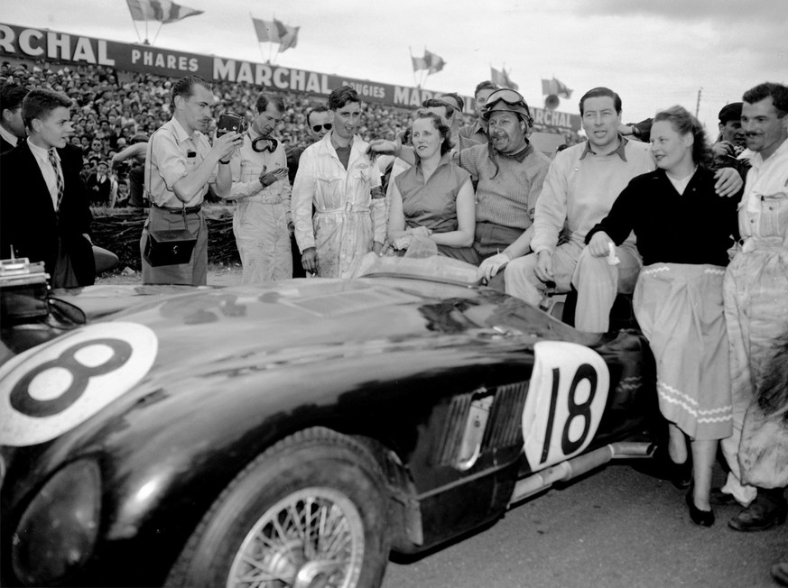 Duncan Hamilton, centre, poses alongside his co-driver Tony Rolt and their wives, in their winning Jaguar, after winning the Le Mans 24 race, June 15,1953. The race gave Britain first, second and four ...
